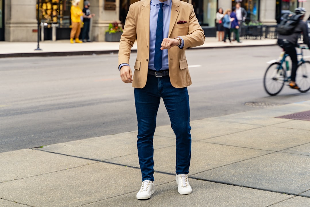 person in blue denim jeans and brown coat standing on sidewalk during daytime — Smart Casual Dress Code: What It Means and How to Dress