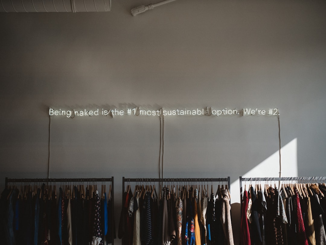assorted clothes lot on gray clothes racks — How to Shop Secondhand for Work Clothes: Thrift and Vintage Workwear Guide